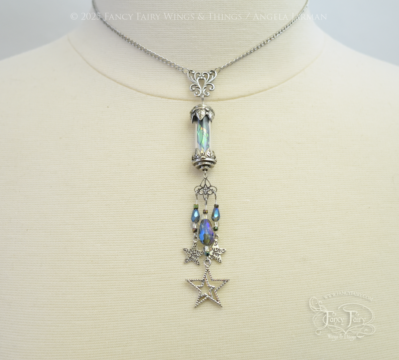 Silver necklace with vial containing fairy wings & star charms dangling from the bottom