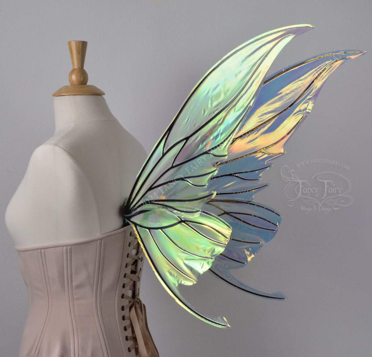 Iridescent transparent green / orange / yellow fairy wings with small tails & black veins worn on a dress form, back 3/4 view