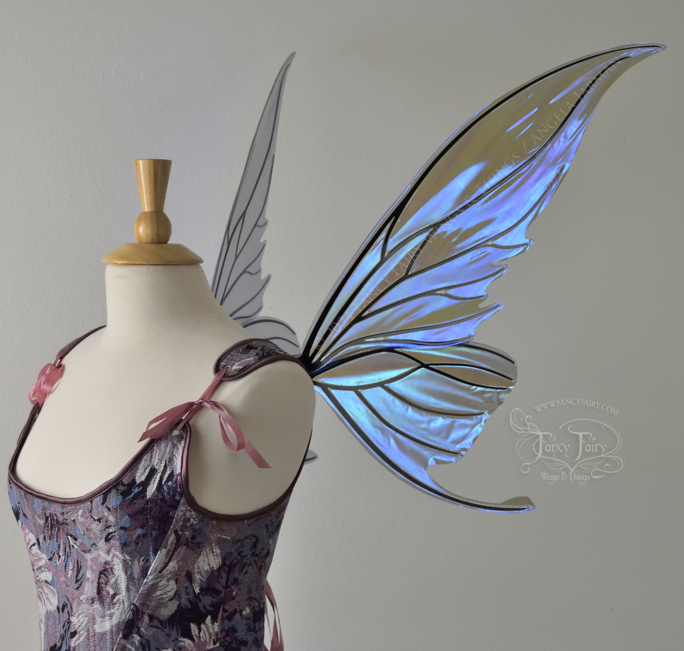 Iridescent purple / blue fairy wings with small tails & black veins worn on a dress form, right side view