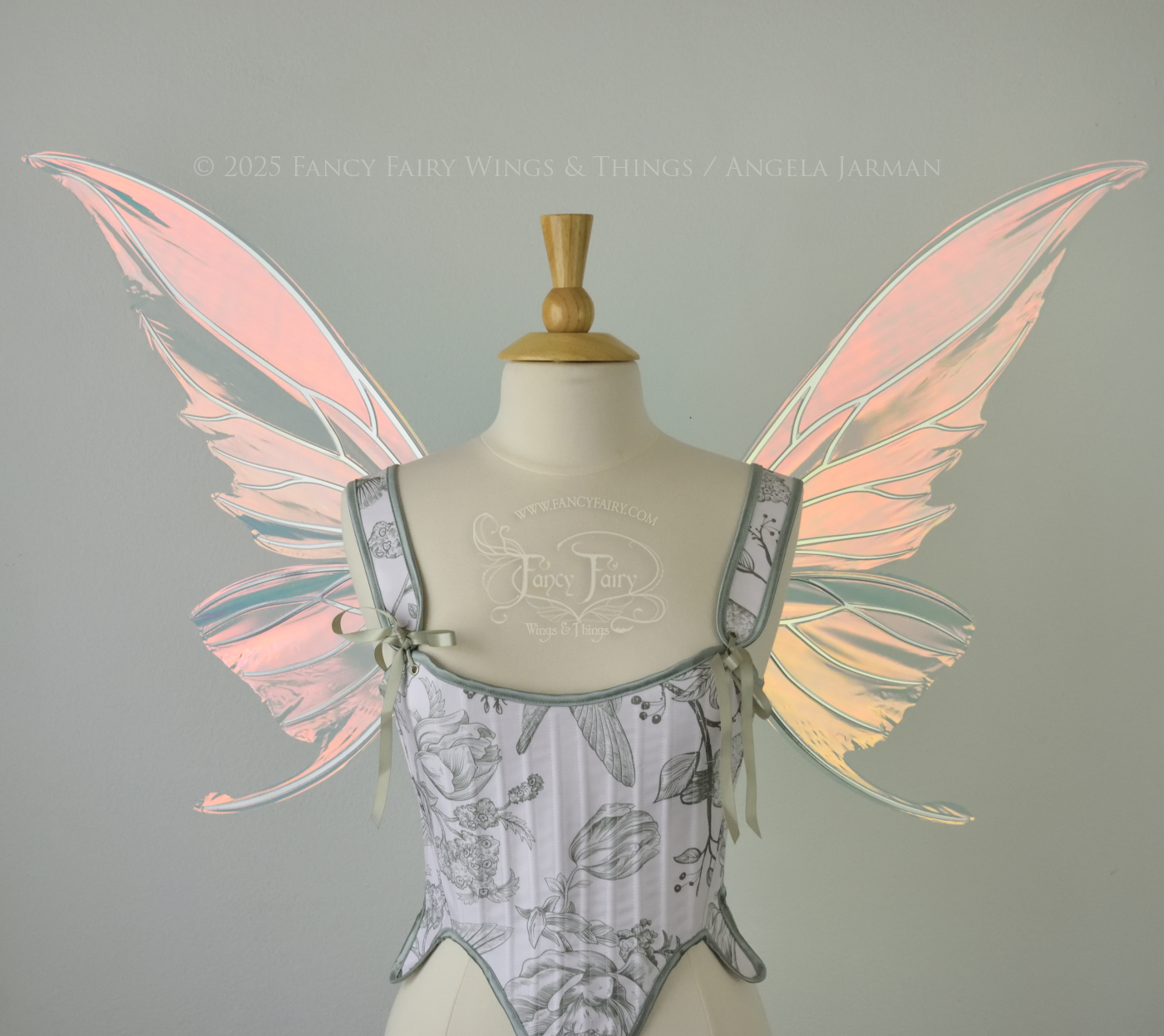 Iridescent pink & orange fairy wings with silver veins, and tails on the bottom panels that curve upwards, worn on a dress form, front view