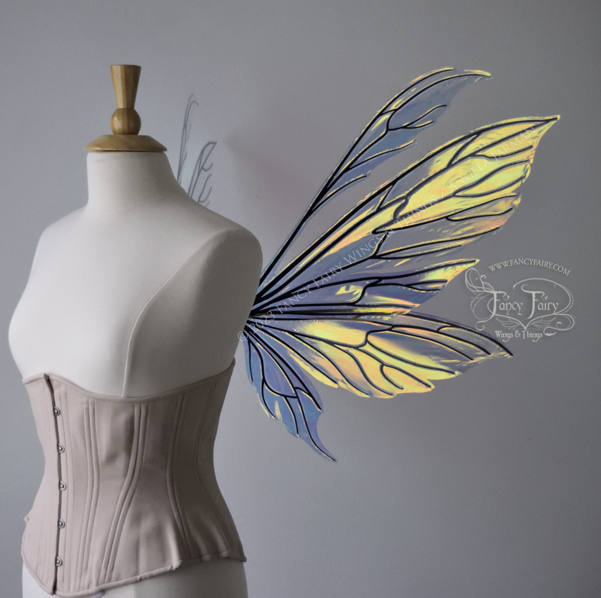 Transparent iridescent fairy wings with 3 panels on each side and antennae with black veins, worn on a dress form, right side view