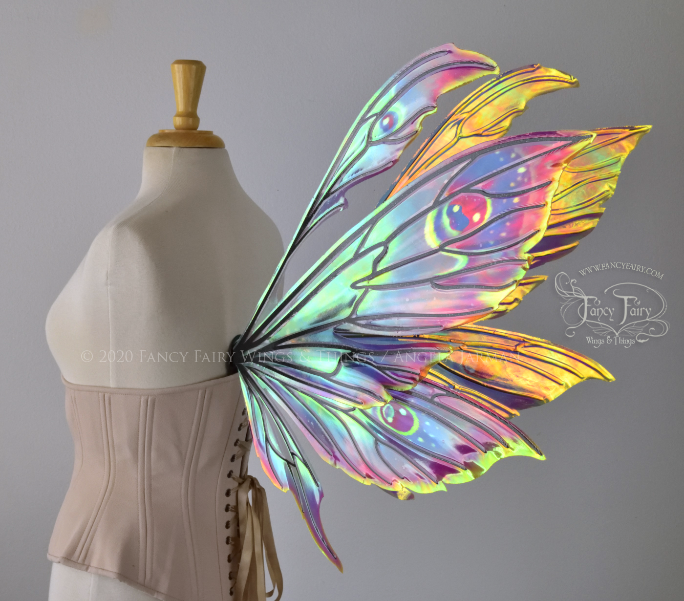 iridescent rainbow fairy wings with black veins, worn on a dress form, back 3/4 view