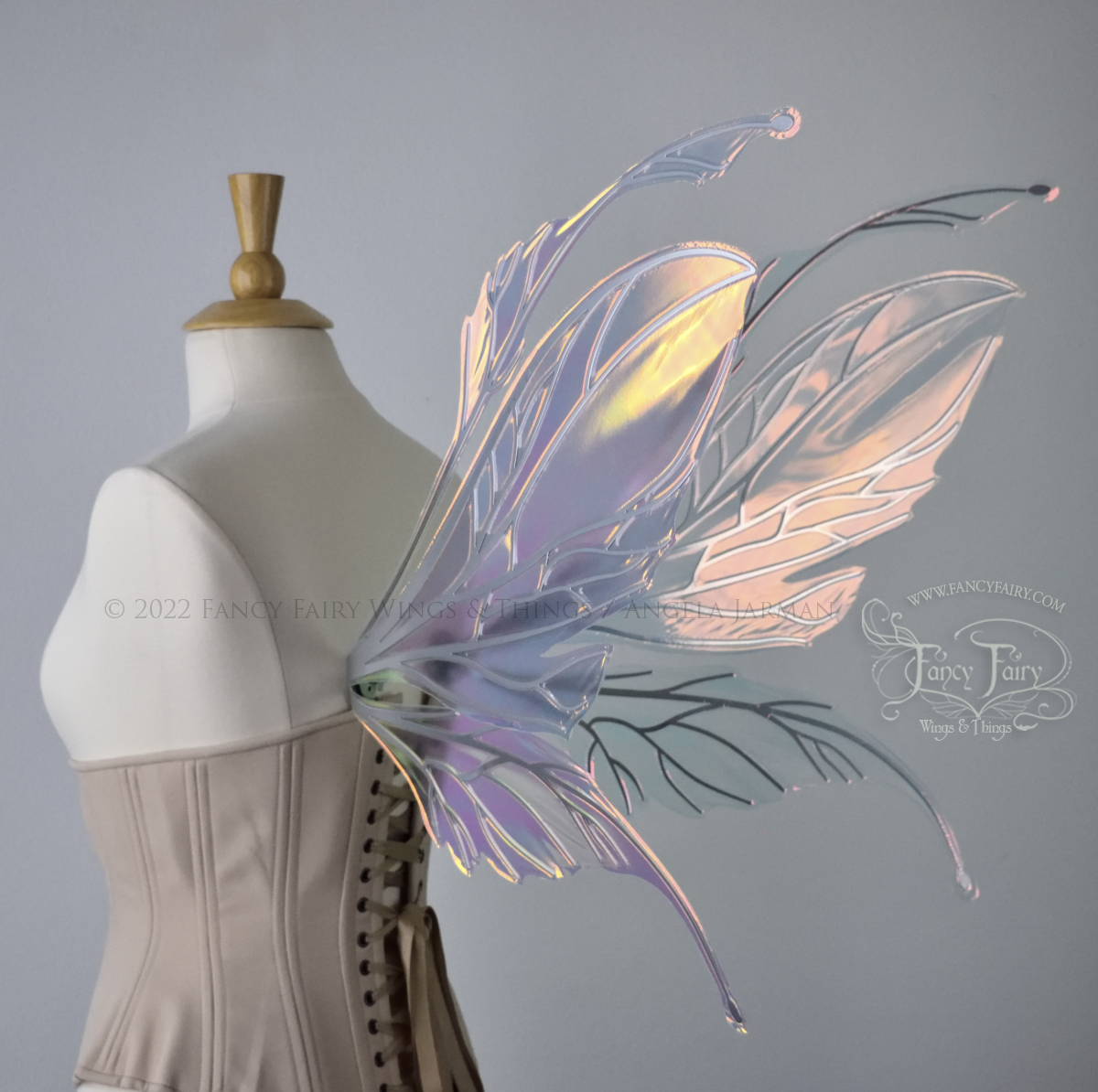 Large pink / orange iridescent fairy wings with antennae along the top, with silver veins, worn on a dressform. Back 3/4 view