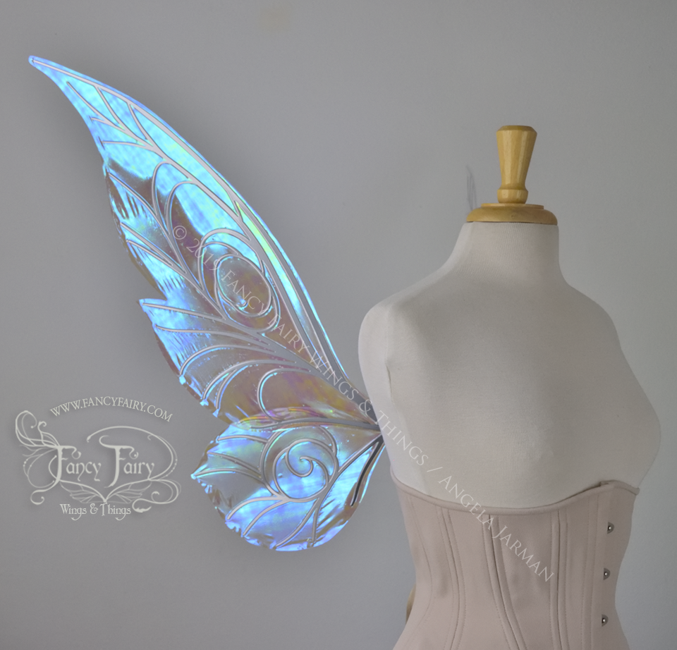 Left side view of transparent blue iridescent Tinker Bell inspired fairy wings with swirly white veins, displayed on a dress form