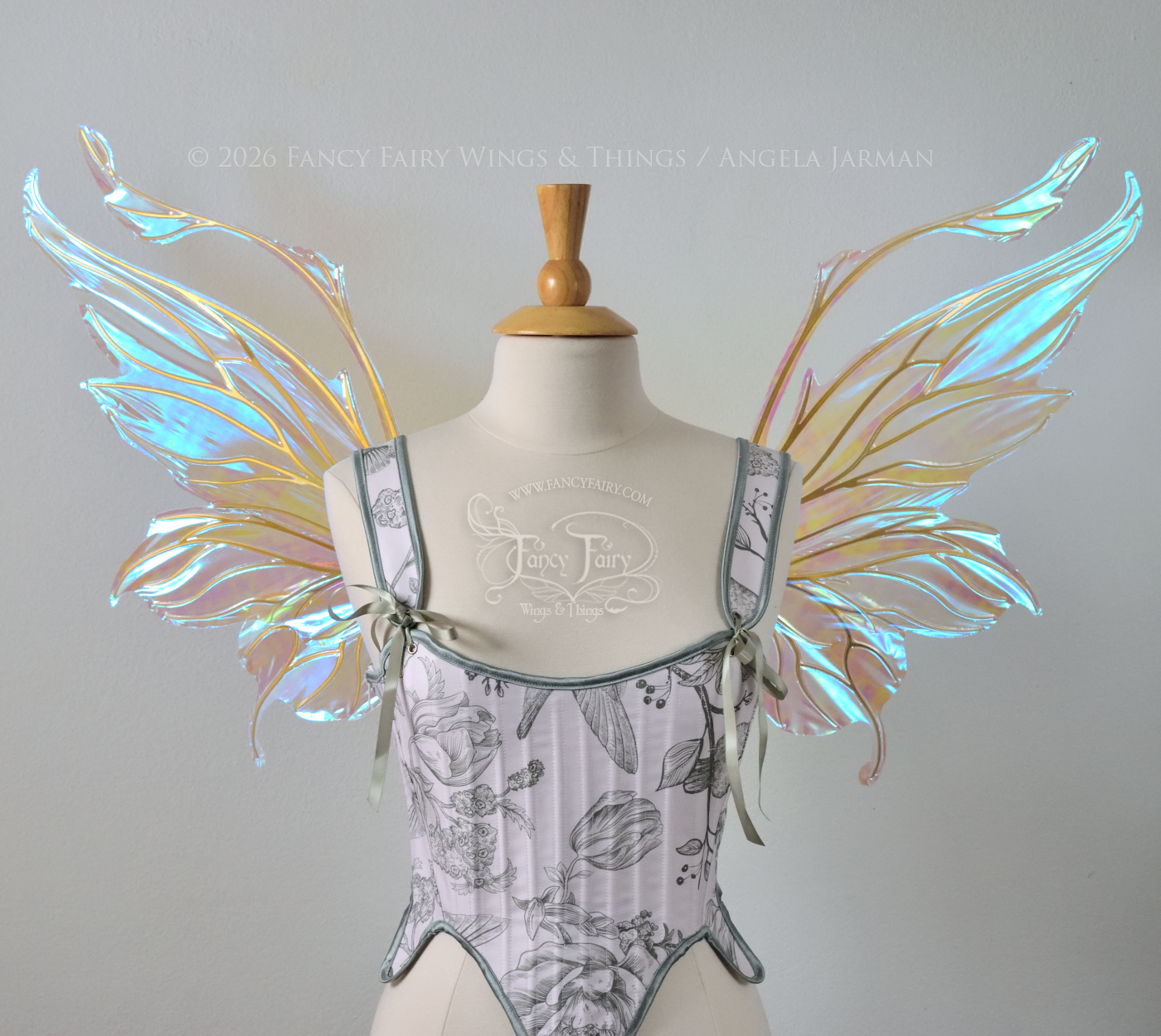 Transparent & iridescent fairy wings with blue shine and gold veins have antennae & upward curving tips, worn on a dress form, front view