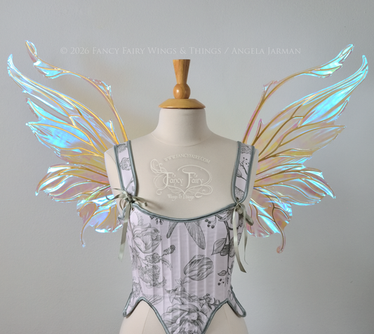 Transparent & iridescent fairy wings with blue shine and gold veins have antennae & upward curving tips, worn on a dress form, front view
