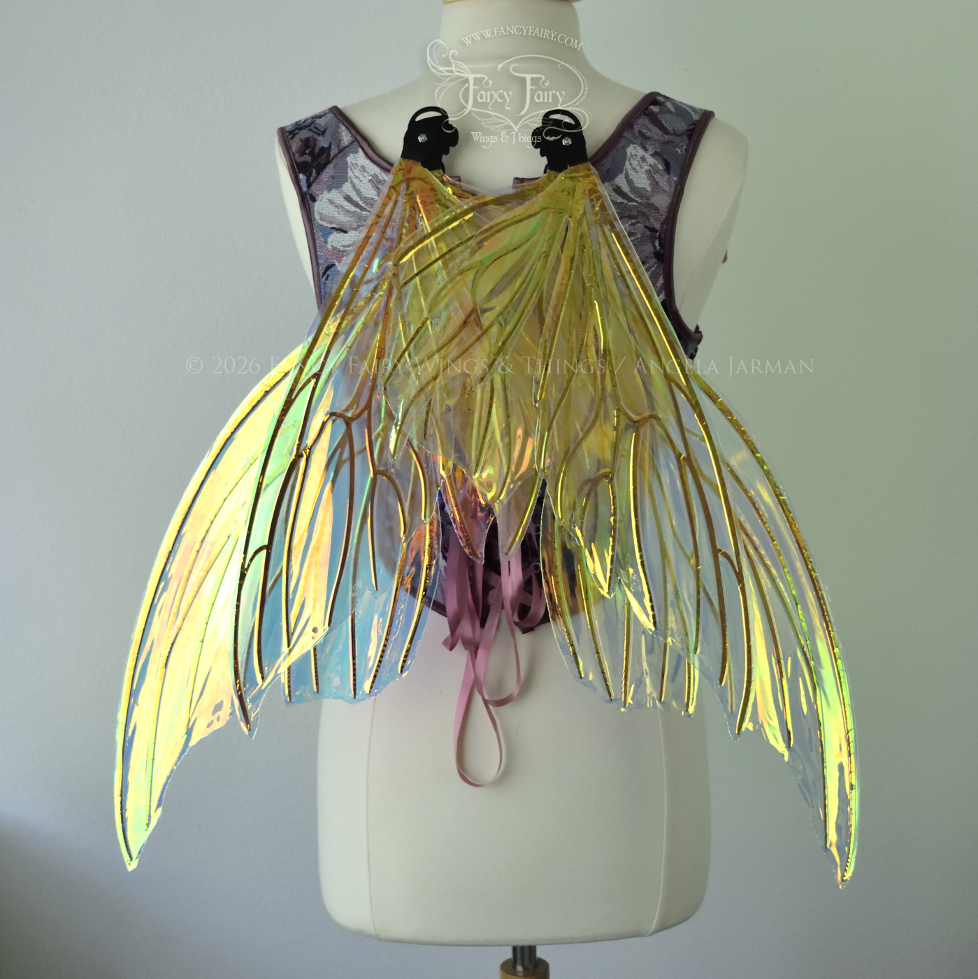Iridescent yellow/orange/green transparent fairy wings with lots of 'thorny' black veins, worn on a dress form, back view, in resting position