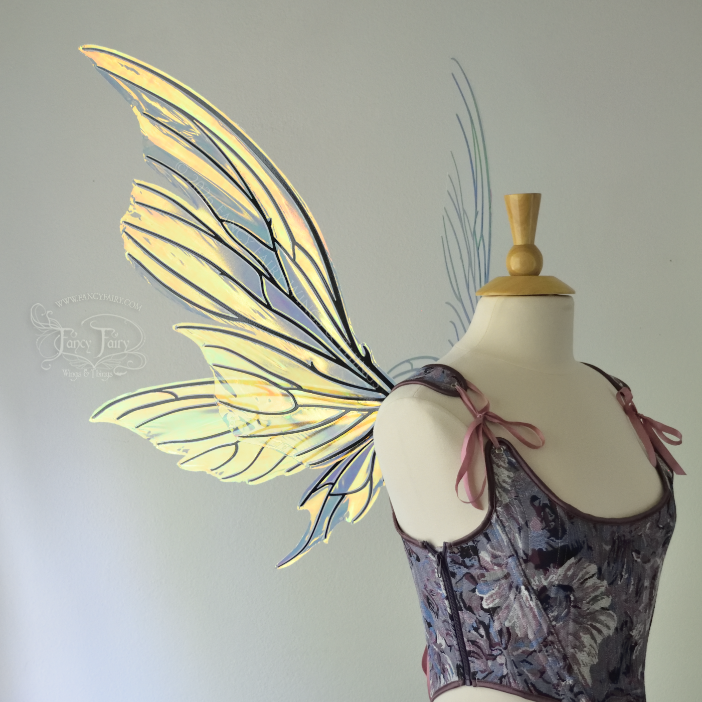 Iridescent yellow/orange/green transparent fairy wings with lots of 'thorny' black veins, worn on a dress form, left side view
