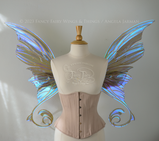 Front view of an ivory dress form wearing an alabaster underbust corset and large purple iridescent fairy wings with lots of intricate gold veins, some have 'thorns'. Upper panels curve slightly downwards along top edge with pointy tips, bottom panels have tails