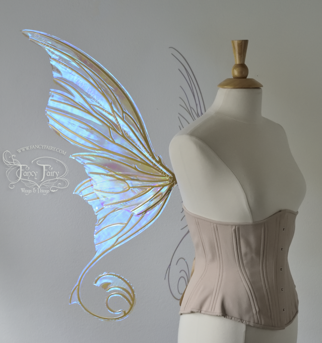 Left side view of a dress form wearing an underbust corset & large blue iridescent fairy wings with lots of intricate veins, some have 'thorns'. Upper panels curve slightly downwards along top edge with pointy tips, bottom panels have tails