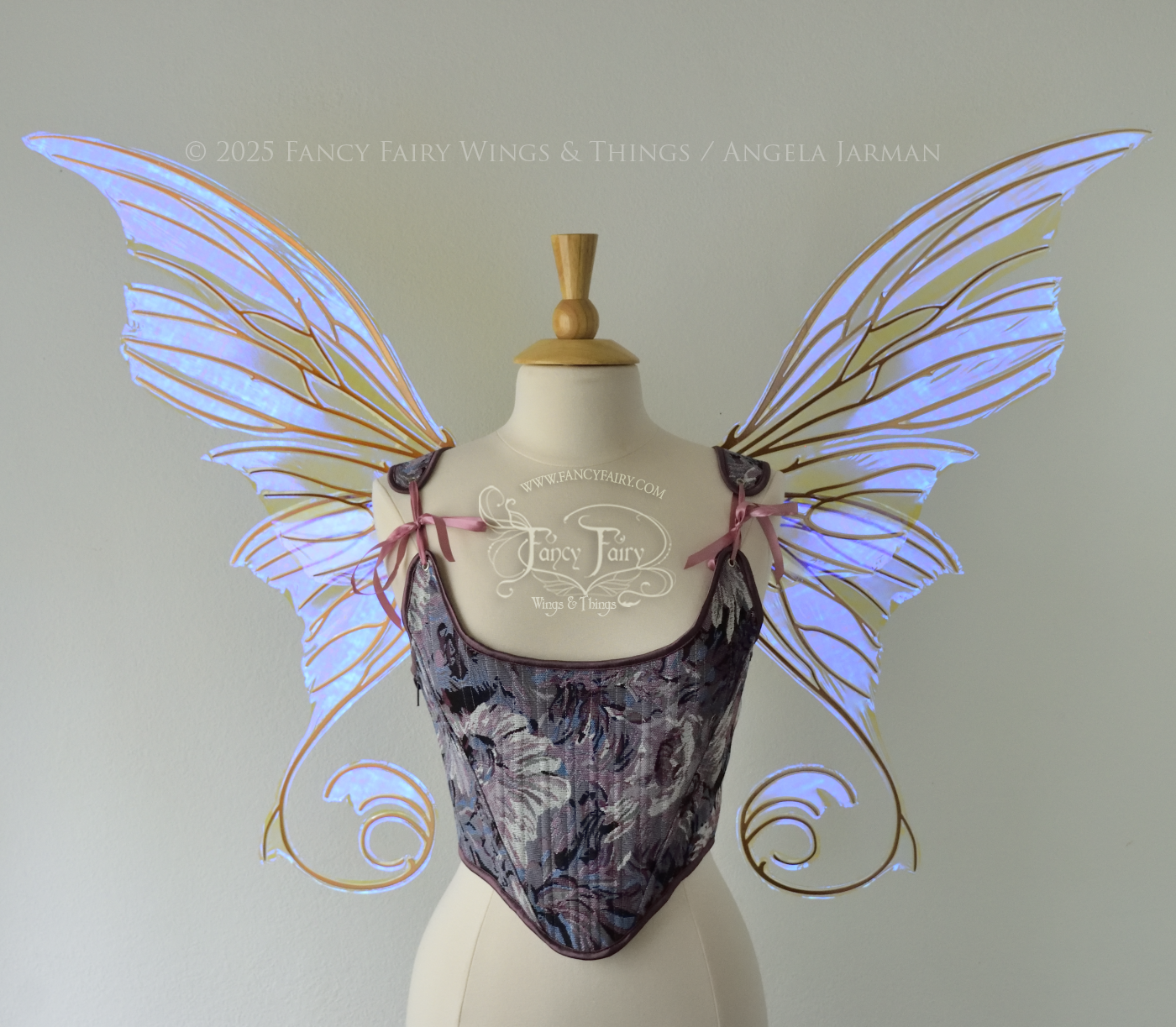 Front view of an ivory dress form wearing large clear violet iridescent fairy wings with lots of intricate copper veins, some have 'thorns'. Upper panels curve slightly downwards along top edge with pointy tips, bottom panels have tails