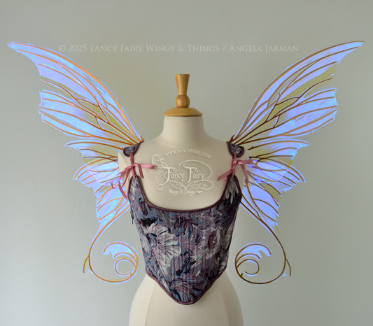 Front view of an ivory dress form wearing large clear violet iridescent fairy wings with lots of intricate copper veins, some have 'thorns'. Upper panels curve slightly downwards along top edge with pointy tips, bottom panels have tails