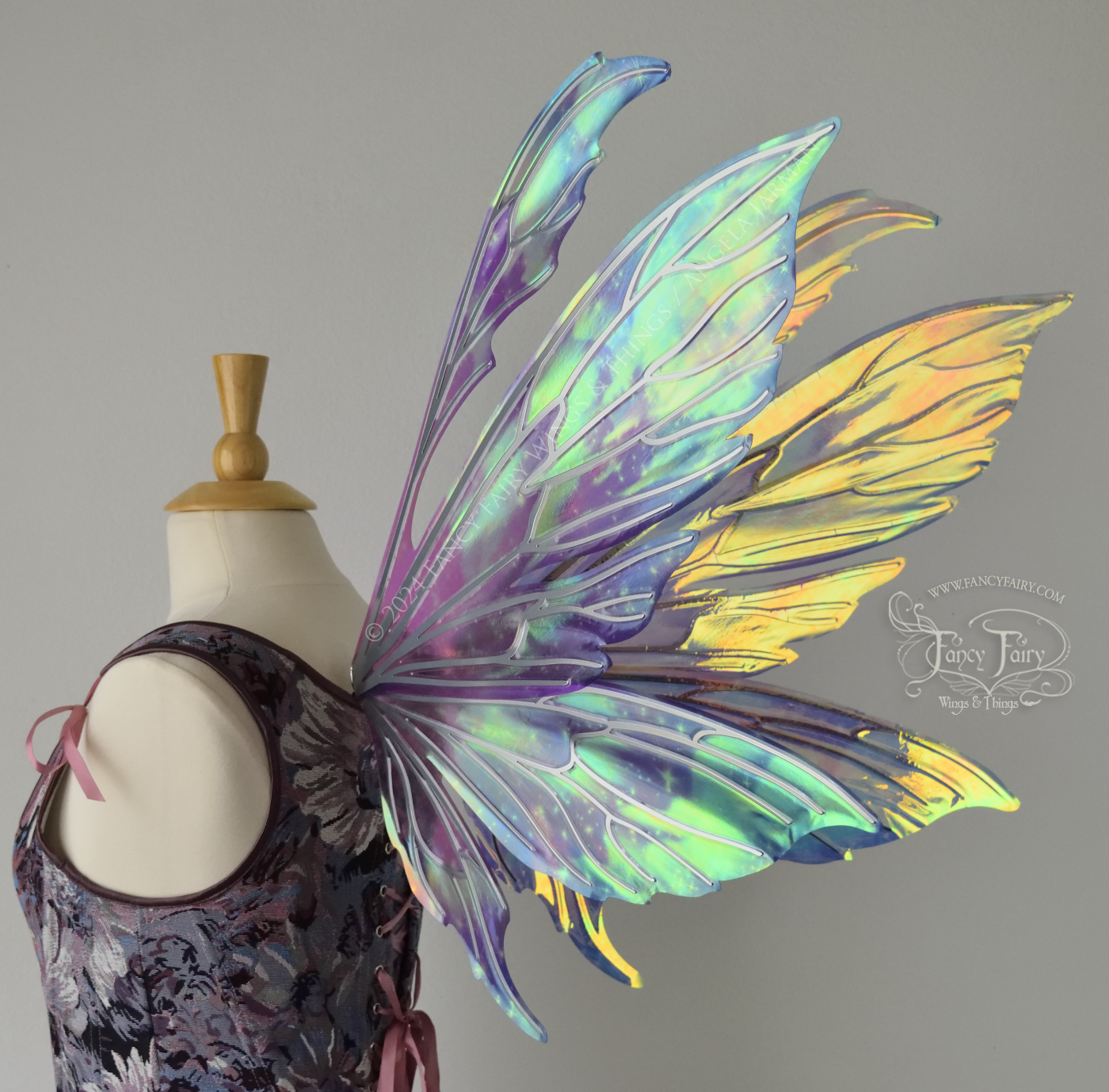 Iridescent fairy wings with pointed tips & antennae, painted with auroras & stars in pinks, purples & blues, with silver veins, back 3/4 view