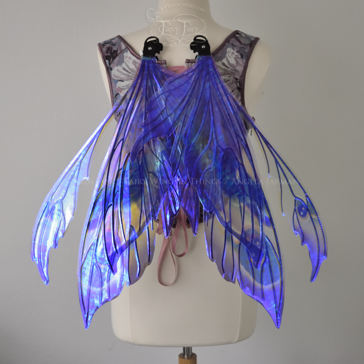 Large transparent fairy wings with antennae have peacock 'eye' accents painted on violet iridescent film with black veins, worn on dress form, back view in resting position
