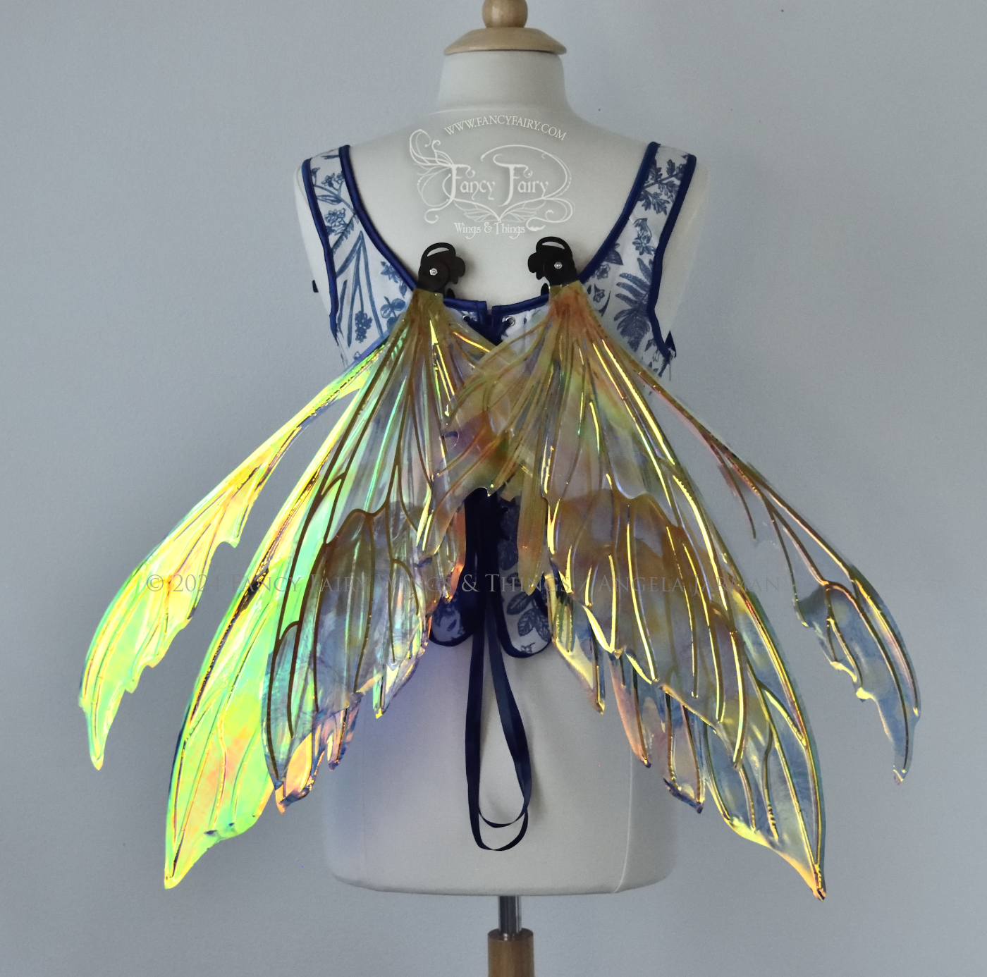 Iridescent fairy wings painted like Van Gogh's Starry Night, worn on a dress form, back view, in resting position