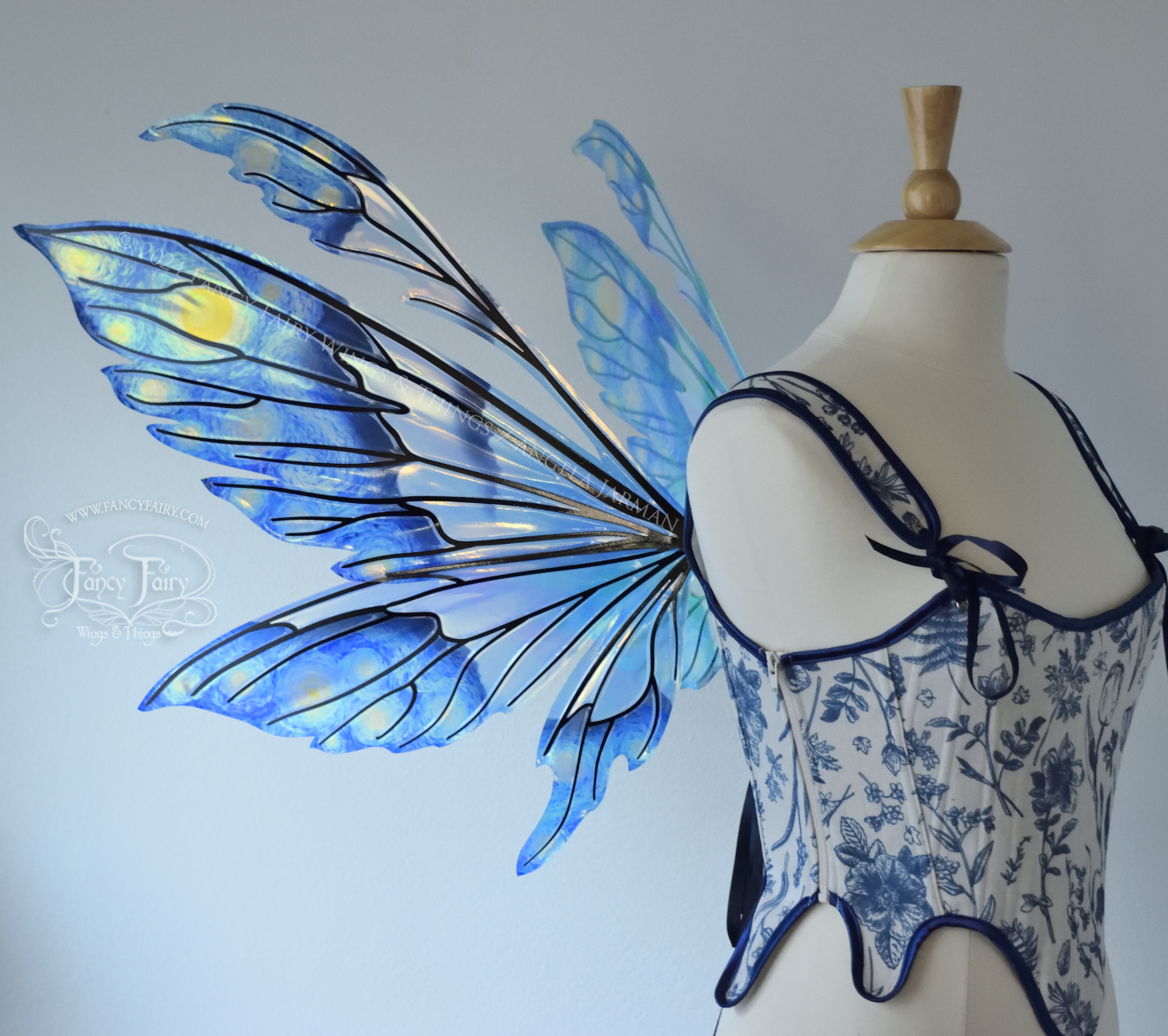 Iridescent fairy wings painted like Van Gogh's Starry Night, worn on a dress form, left side view