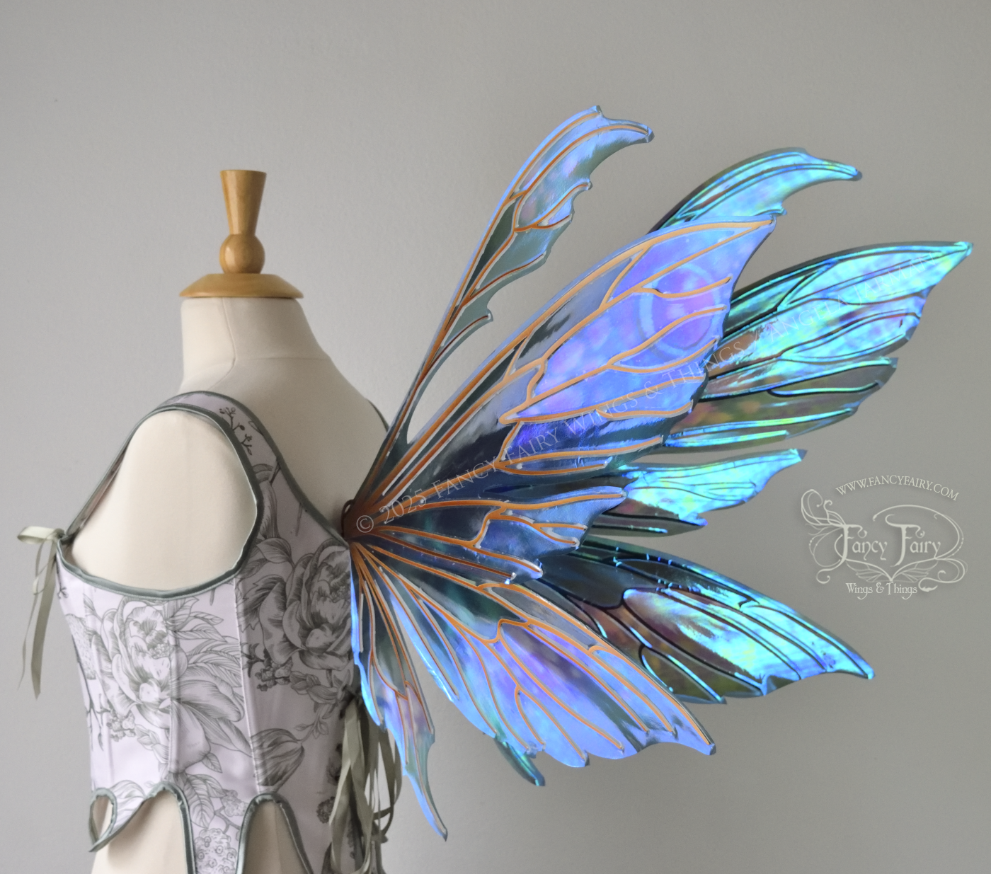 Large iridescent fairy wings with antennae in shades of teal with pink & lavender accents & copper veins, worn on a dress form, back 3/4 side view