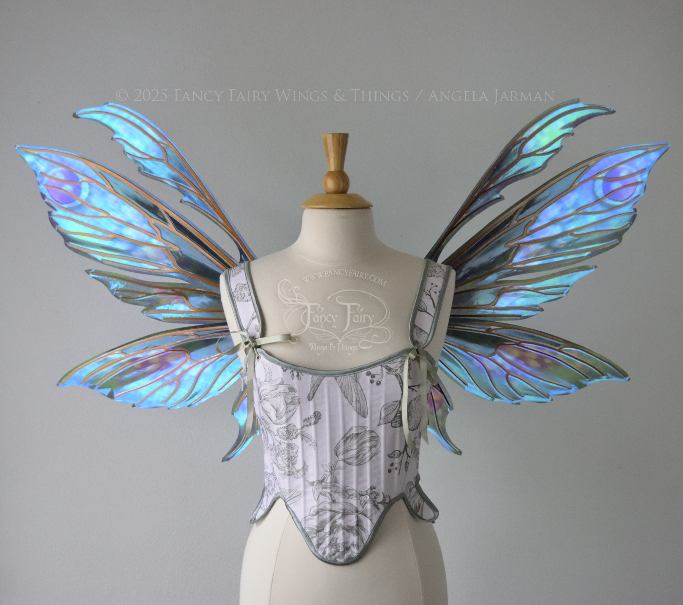 Large iridescent fairy wings with antennae in shades of teal with pink & lavender accents & copper veins, worn on a dress form, front view