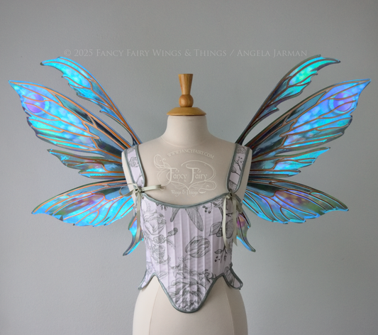 Large iridescent fairy wings with antennae in shades of teal with pink & lavender accents & copper veins, worn on a dress form, front view