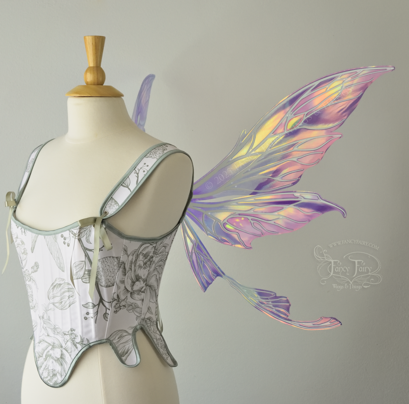 Large painted iridescent fairy wings in berry colors with white veins. Upper panels are elongated with pointed tips, curved ‘tail’, worn on a dress form, right side view