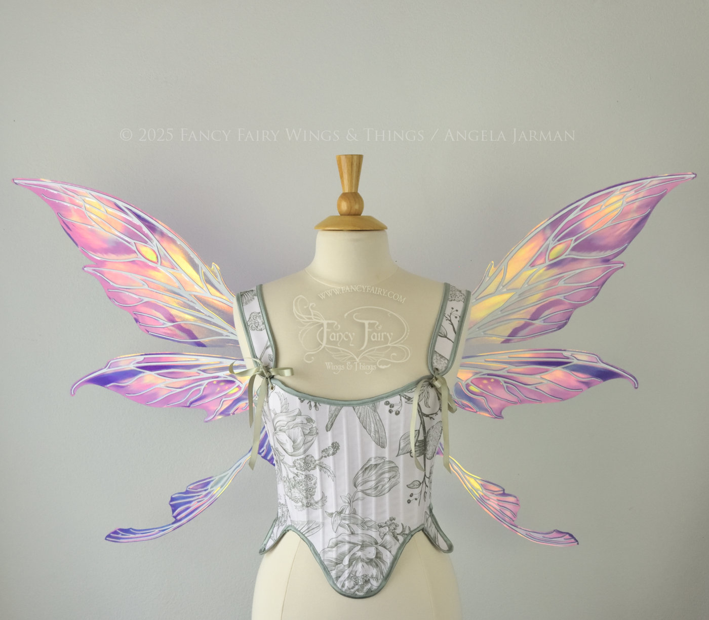 Large painted iridescent fairy wings in berry colors with white veins. Upper panels are elongated with pointed tips, curved ‘tail’, worn on a dress form, front view