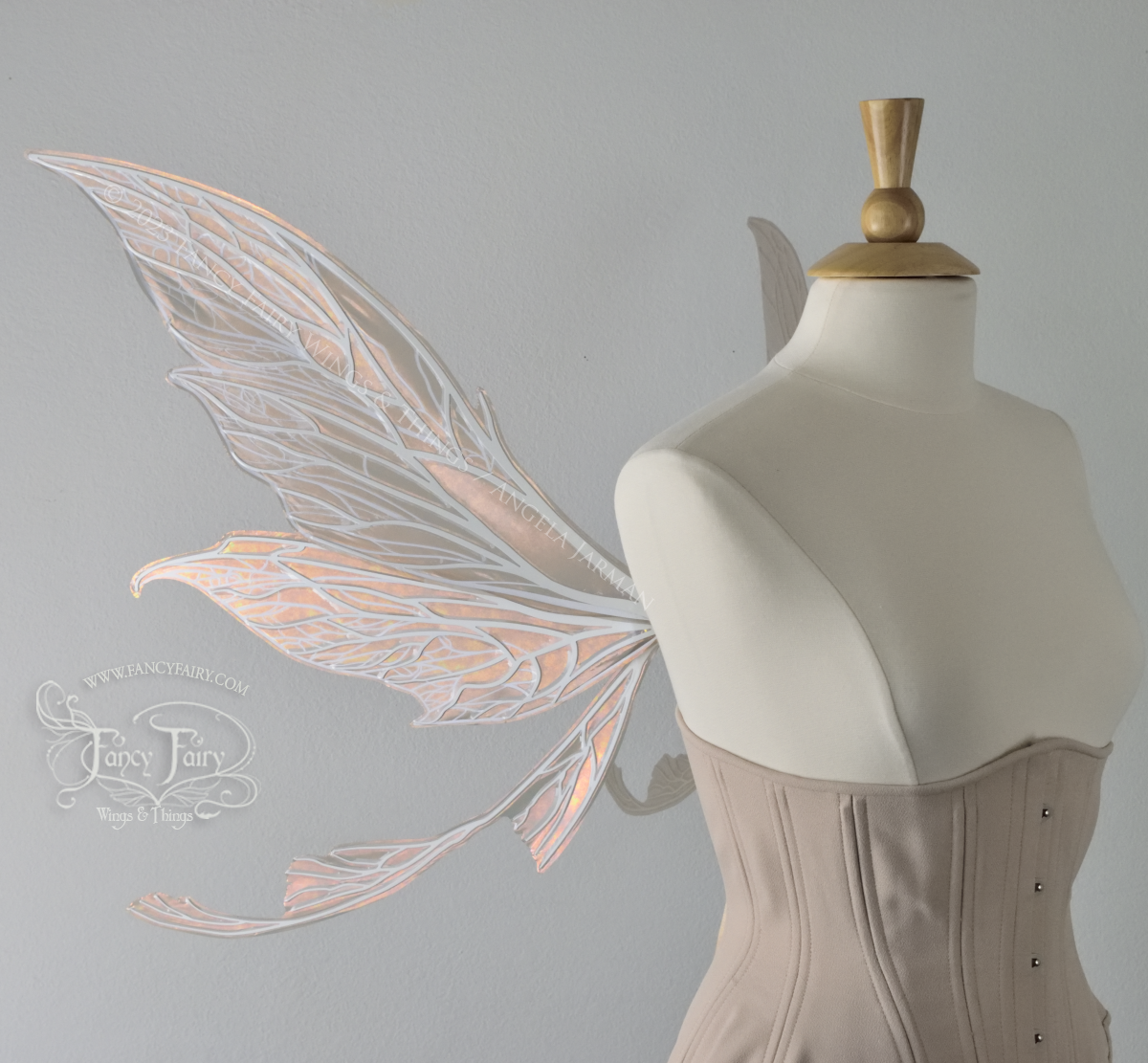 Lft side view of dress form wearing an underbust corset & large Rose Gold iridescent fairy wings with tails & lots of detailed white veins.