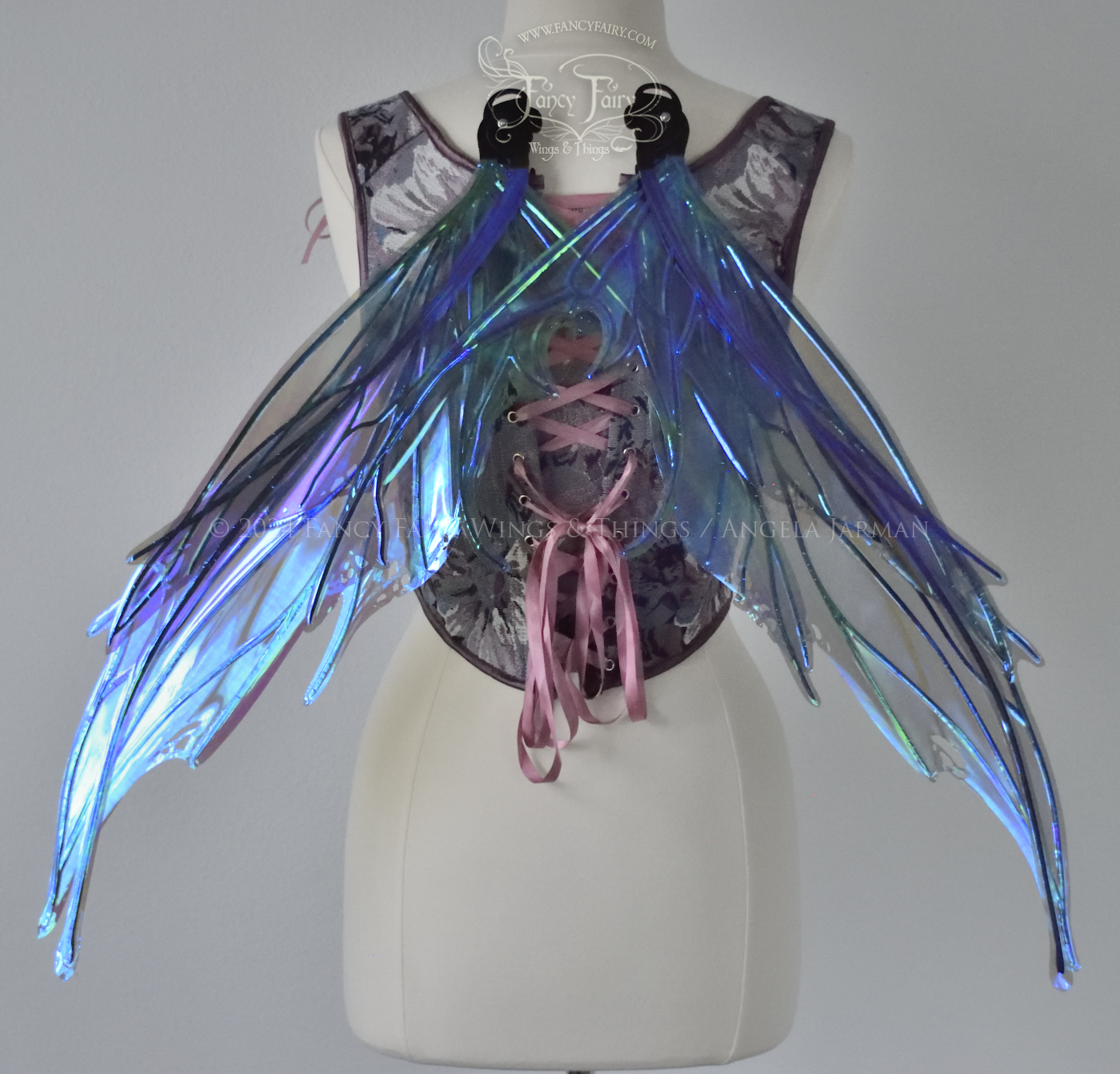 Large spikey iridescent purple & blue fairy wings with black veins and antennae, worn on a dress form, back view, in resting position