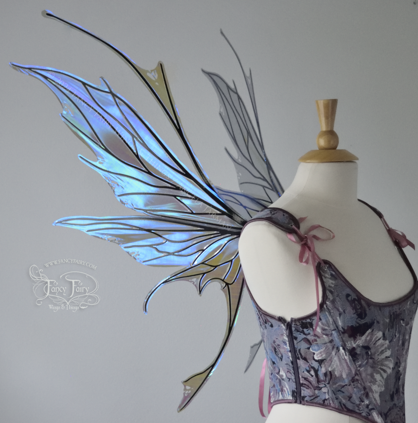 Large spikey iridescent purple & blue fairy wings with black veins and antennae, worn on a dress form, left side view