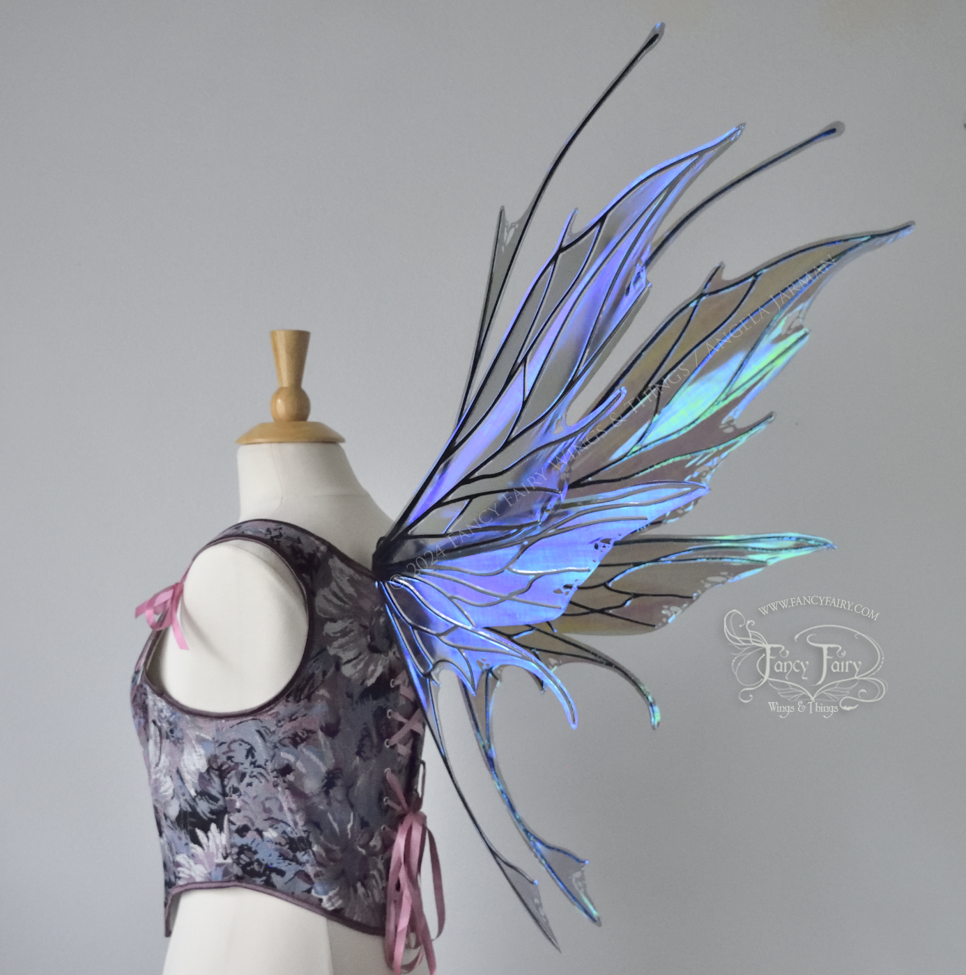 Large spikey iridescent purple & blue fairy wings with black veins and antennae, worn on a dress form, back 3/4 view