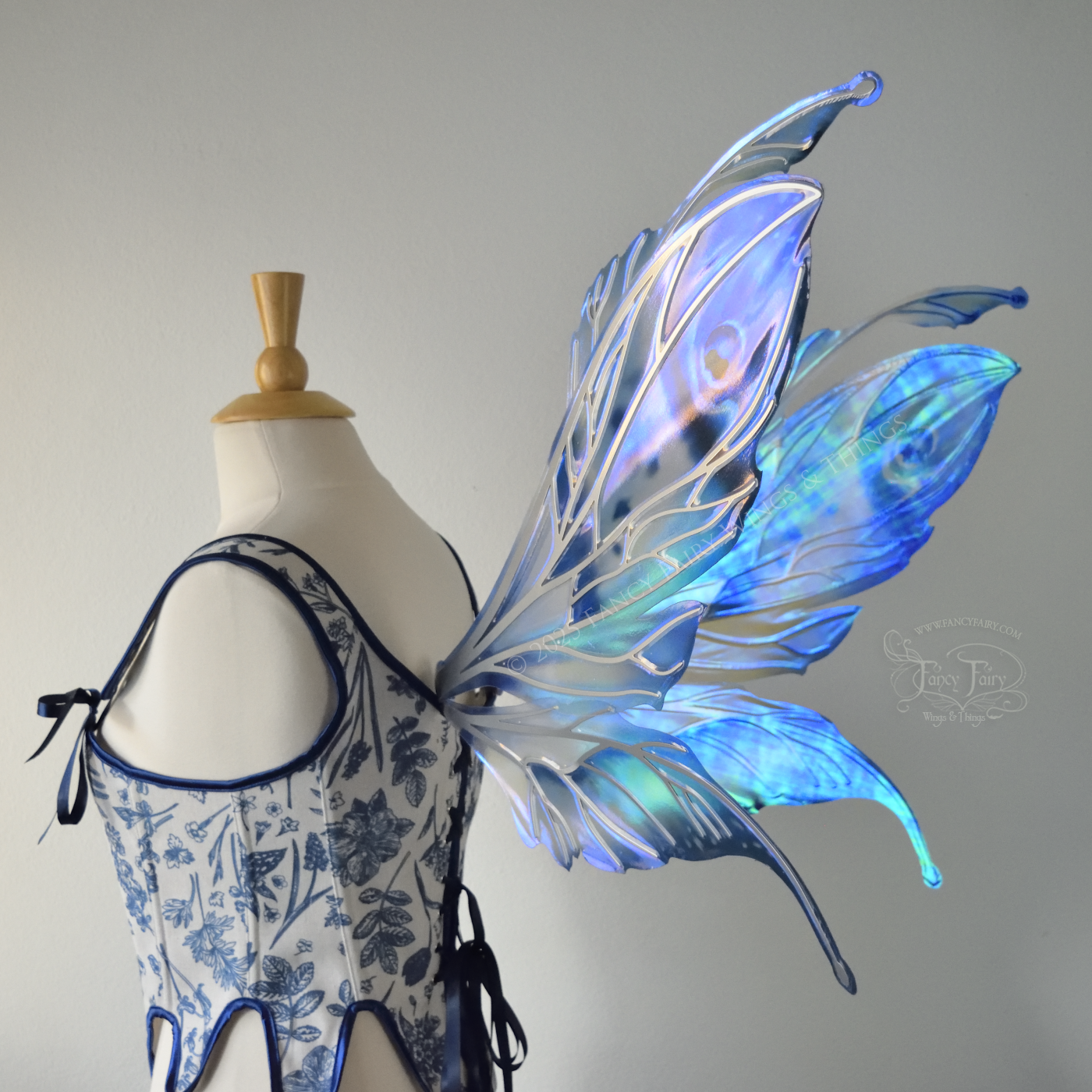 Large blue painted iridescent fairy wings with antennae, silver veins, worn on a dress form, back 3/4 view