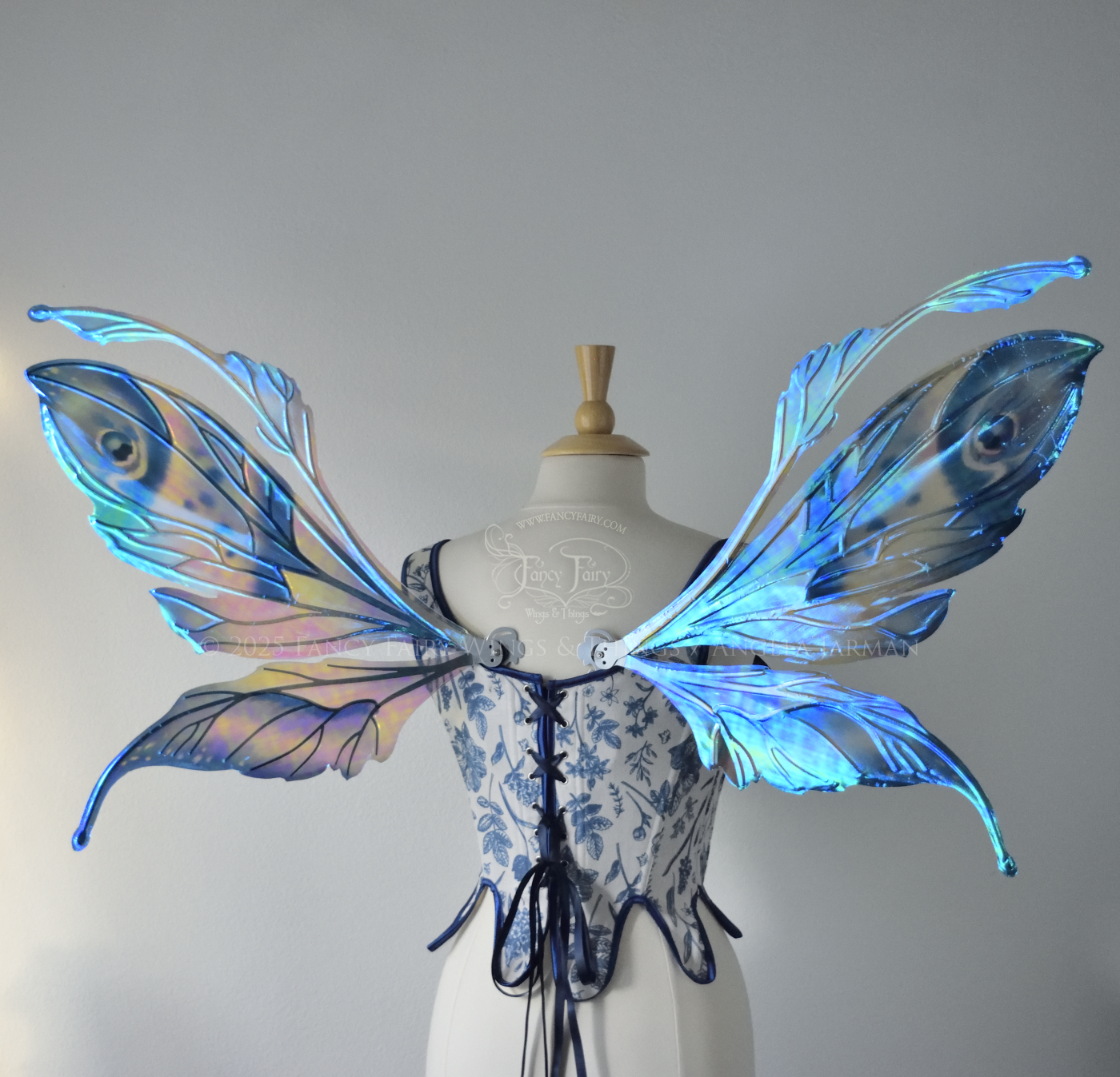 Large blue painted iridescent fairy wings with antennae, silver veins, worn on a dress form, back view