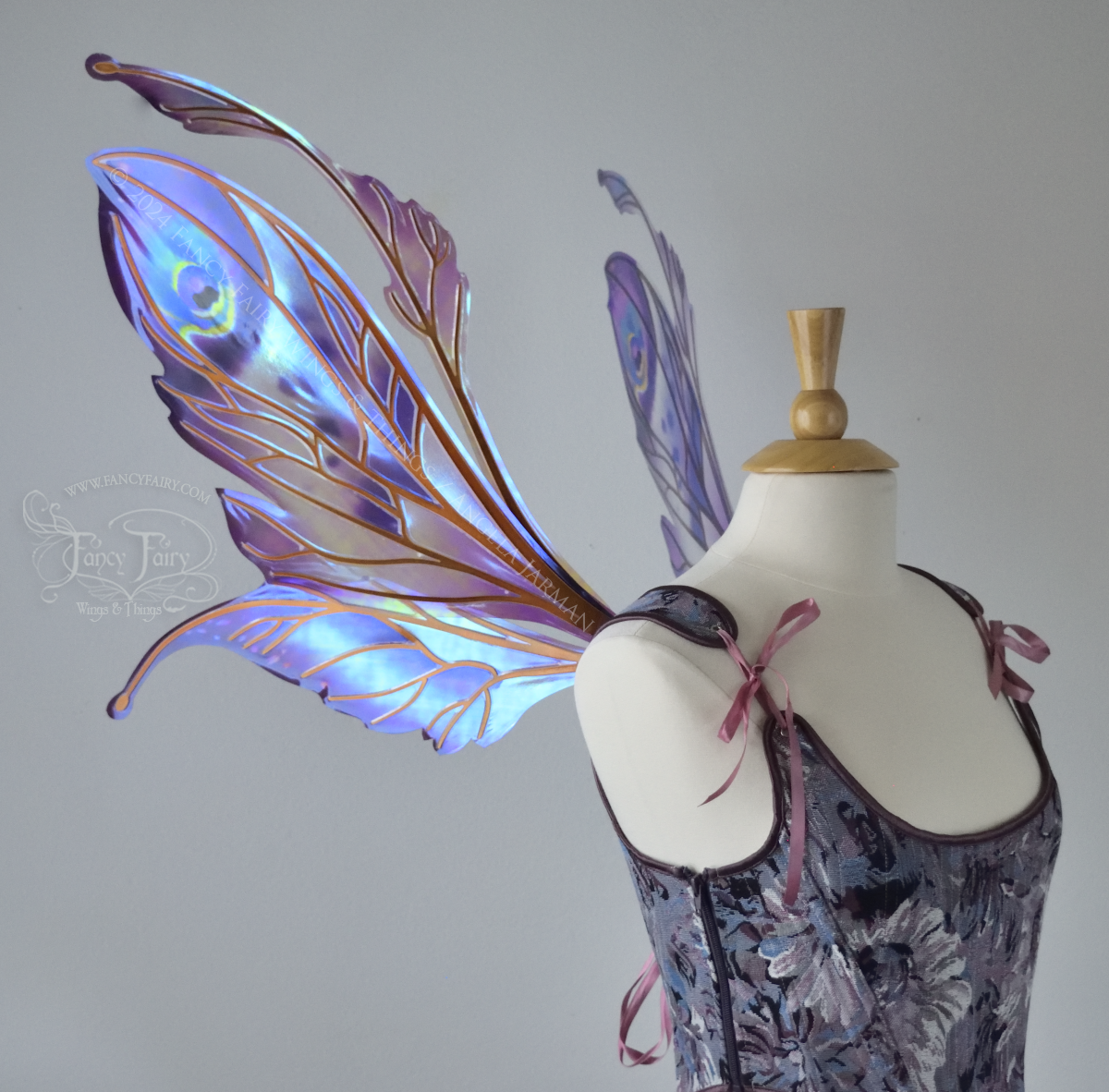 Large mauve, plum and blue iridescent fairy wings with antennae, copper veins, worn with a purple bodice on a dress form, left side view