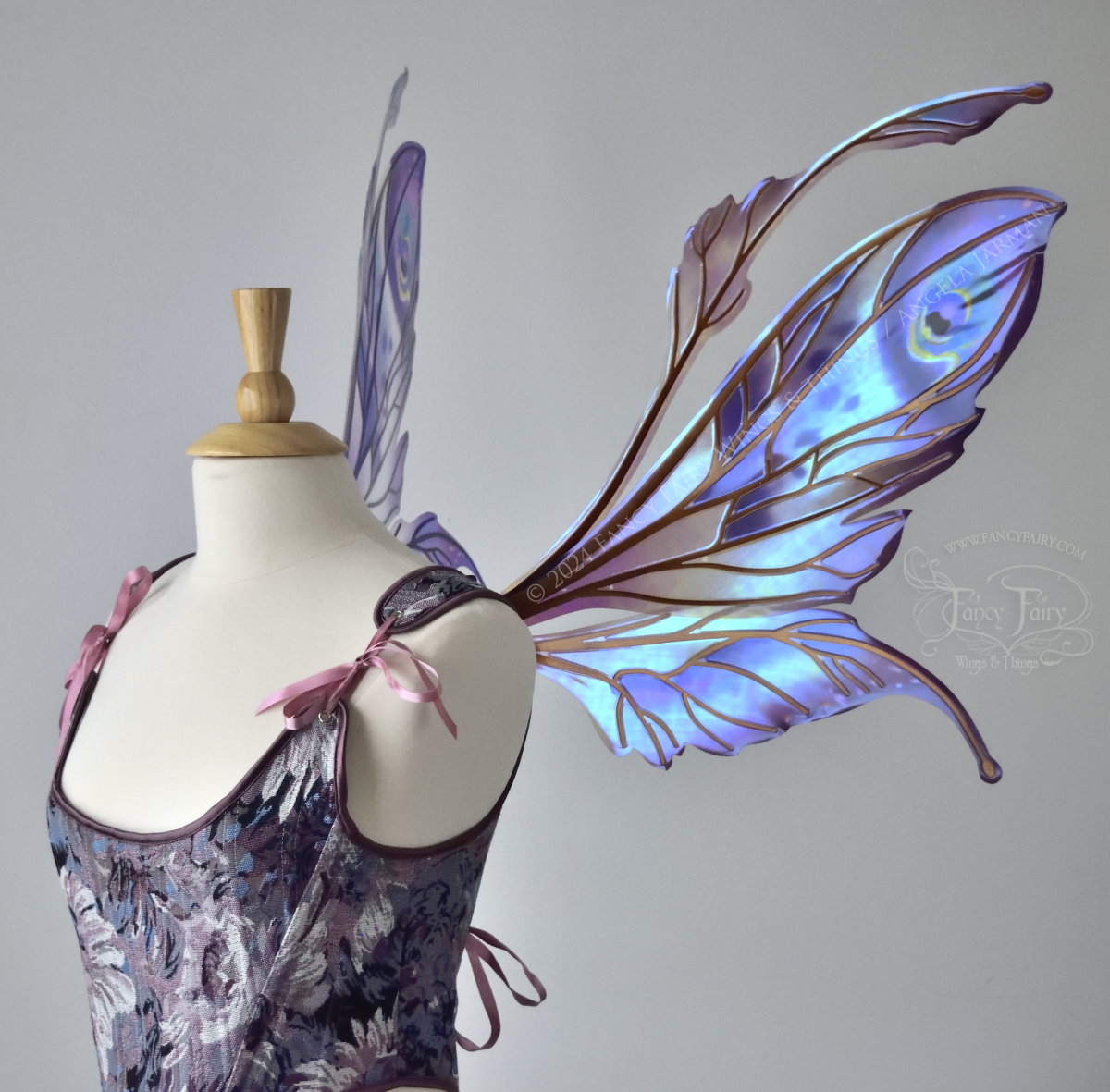 Large mauve, plum and blue iridescent fairy wings with antennae, copper veins, worn with a purple bodice on a dress form, right side view