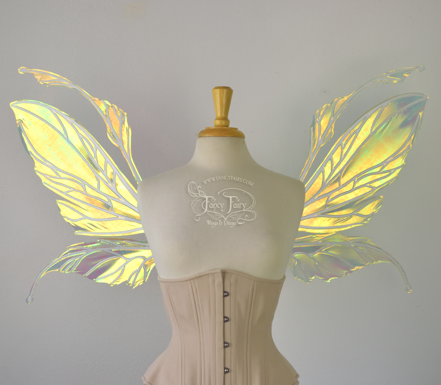 Front view of a dress form wearing an underbust corset and large fairy wings featuring antennae along the top. The upper panels are elongated with semi-pointed tips, the lower panels are smaller with slender tips that curve downward. They are neon yellow iridescent and the veins are white. The background is plain white and my logo and copyright notice are visible.