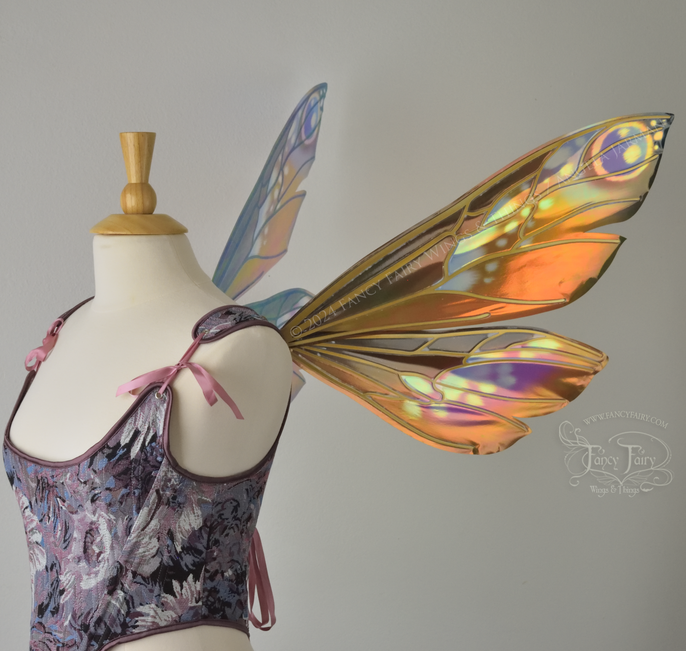 Wasp-shaped iridescent fairy wings in warm orange & rust colors with touches of blue, purple and pink, worn on a dress form, right side view