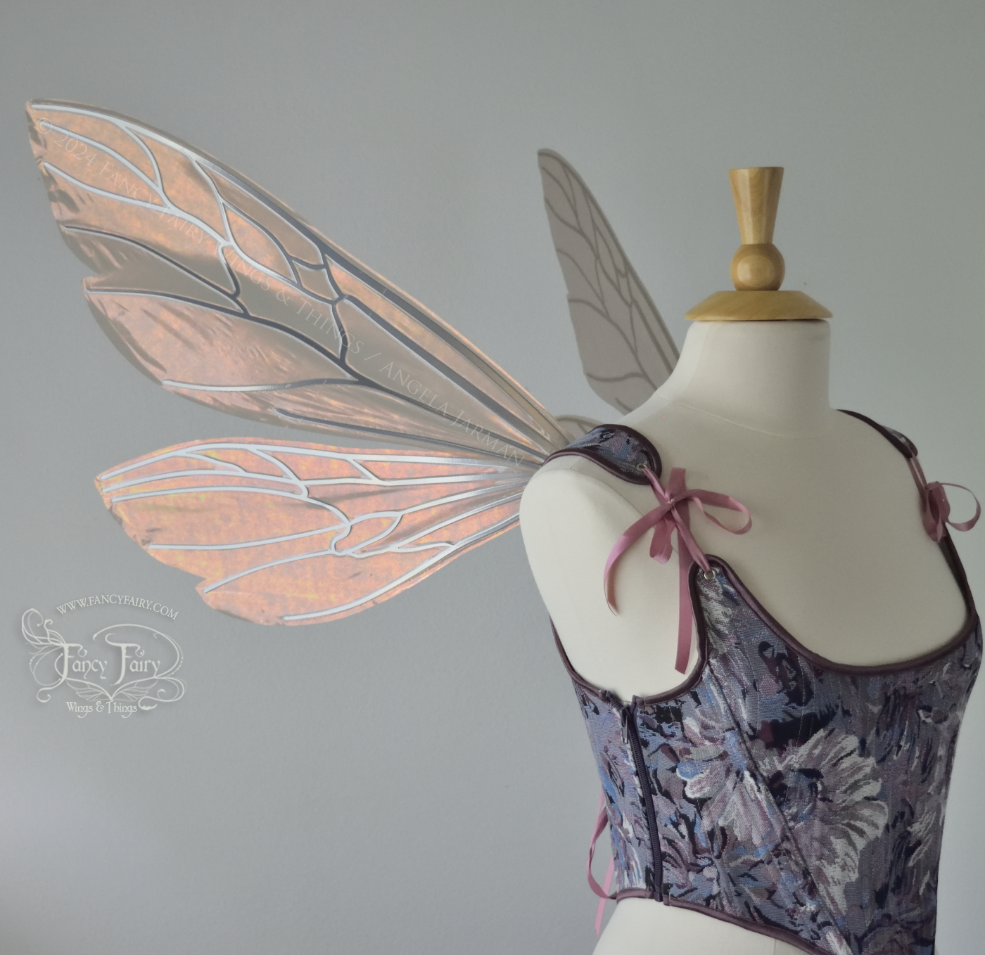 Wasp-shaped fairy wings in iridescent rose gold with silver veins, worn on a dress form, left side view