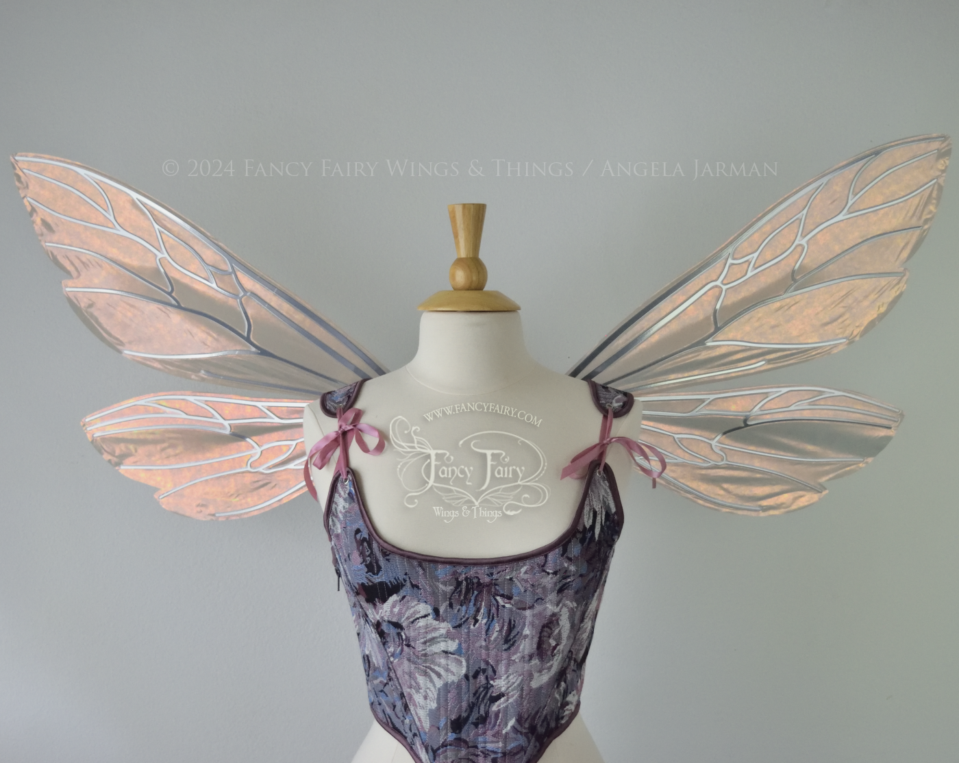 Wasp-shaped fairy wings in iridescent rose gold with silver veins, worn on a dress form, front view