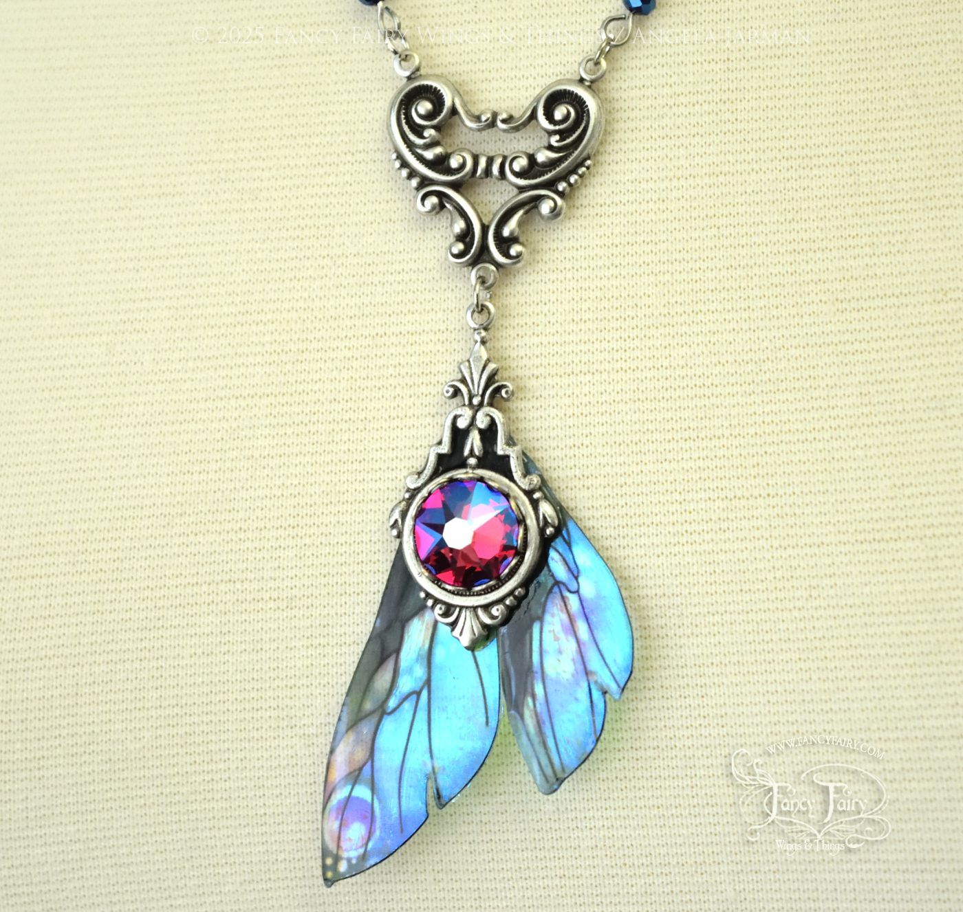 Iridescent fairy wing pendant necklace in teals with pink accents and silver filigree, closeup