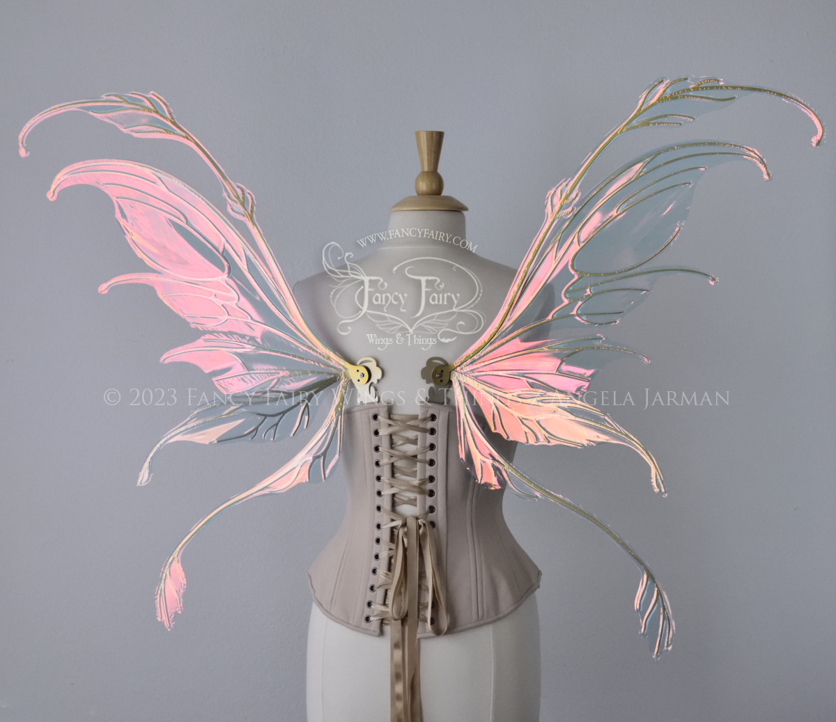 Back view of an ivory dress form wearing an underbust corset & 'Fauna' pinkish iridescent fairy wings with gold veining