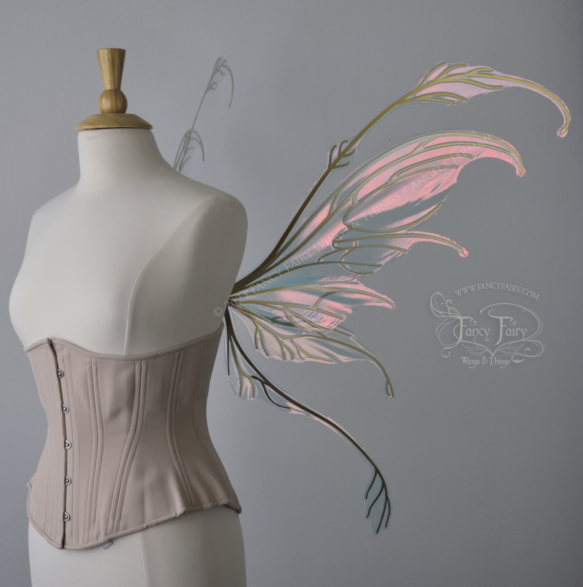 Right side view of an ivory dress form wearing an underbust corset & 'Fauna' pinkish iridescent fairy wings with gold veining