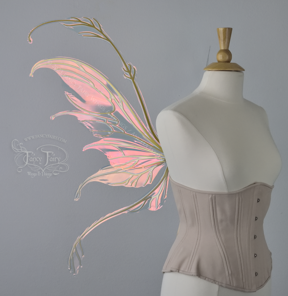 Left side view of an ivory dress form wearing an underbust corset & 'Fauna' pinkish iridescent fairy wings with gold veining