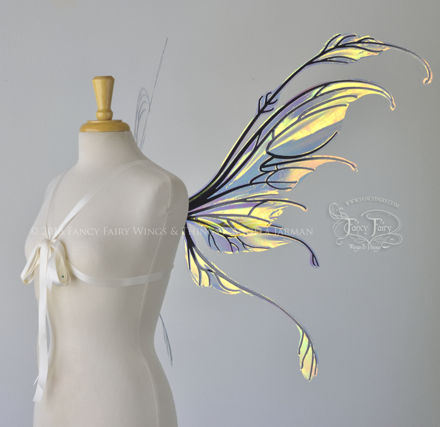 Right side view of a dress form wearing 'Fauna' transparent Diamond Fire iridescent fairy wings with downward curved tips, antennae & wispy 'tails', with black veining