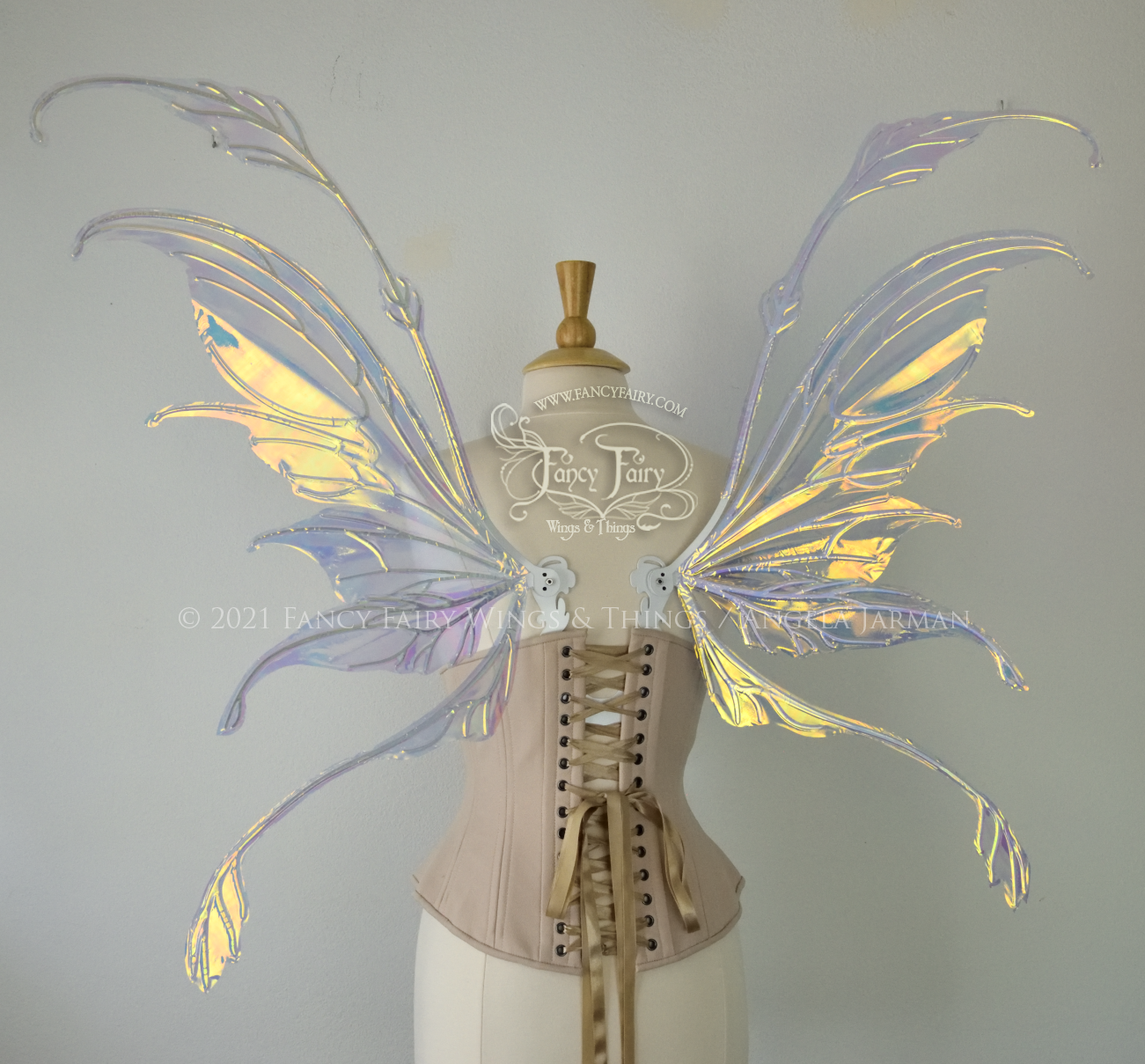 Back view of a dress form wearing an underbust corset & 'Fauna' transparent iridescent fairy wings with downward curved tips, antennae & wispy 'tails', with white veining