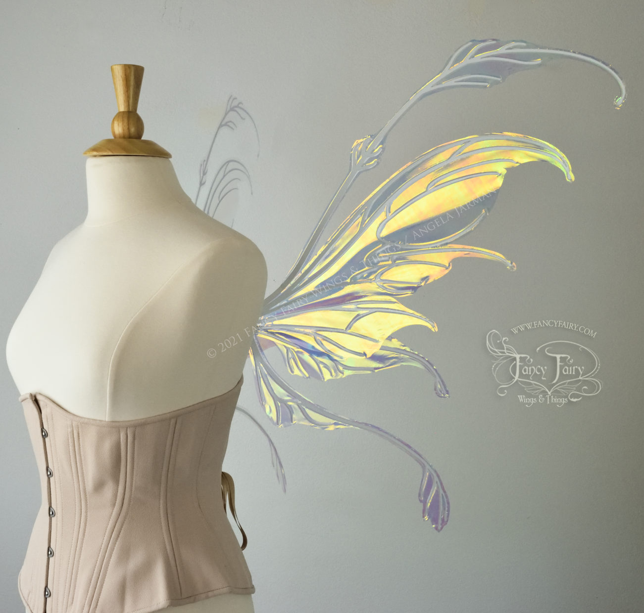 Right side view of a dress form wearing an underbust corset & 'Fauna' transparent iridescent fairy wings with downward curved tips, antennae & wispy 'tails', with white veining