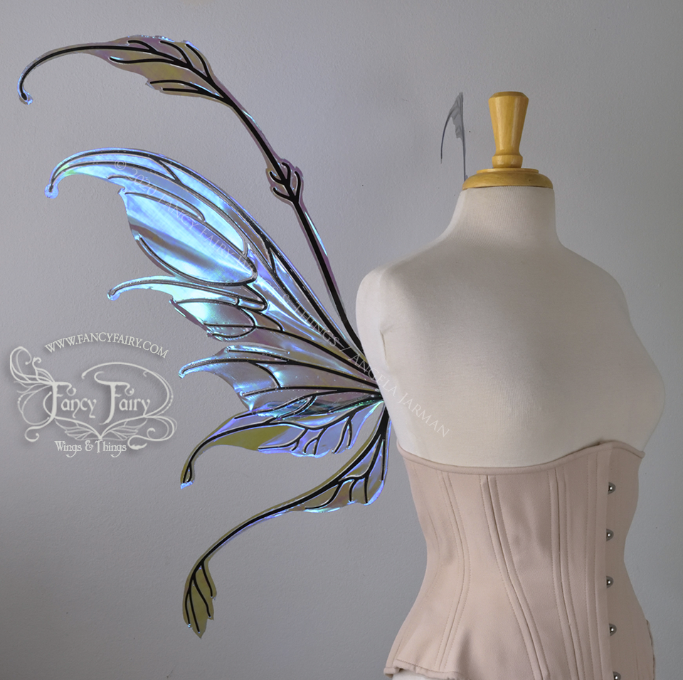 Left side view of a dress form wearing an underbust corset & 'Fauna' transparent purple / blue iridescent fairy wings with downward curved tips, antennae & wispy 'tails', with black veining