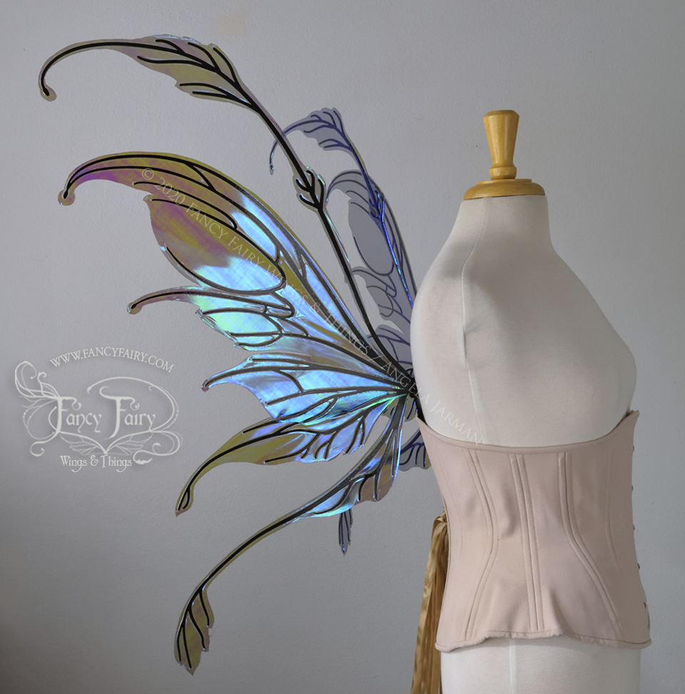 Left side view 2 of a dress form wearing an underbust corset & 'Fauna' transparent purple / blue iridescent fairy wings with downward curved tips, antennae & wispy 'tails', with black veining