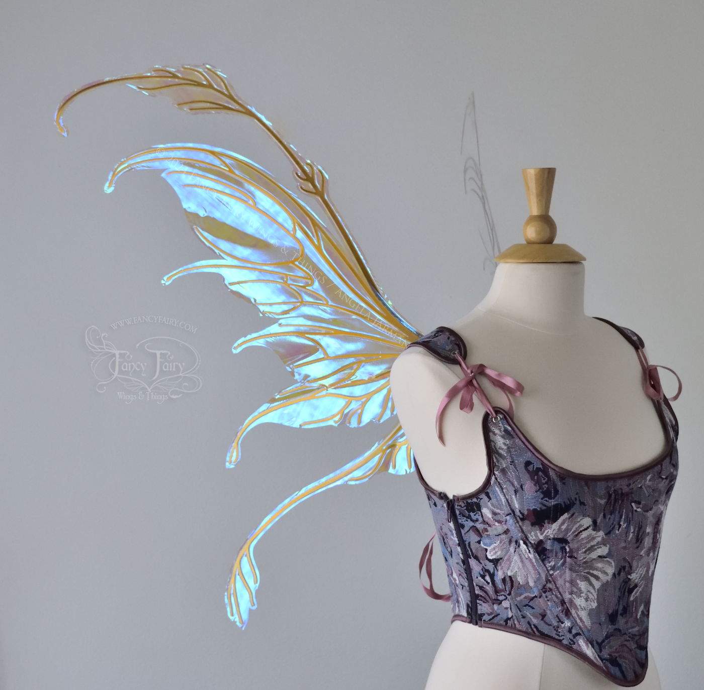 Large blue / green transparent iridescent fairy wings with downward curved tips, antennae & appendages, gold veins, worn on a dress form, left side view