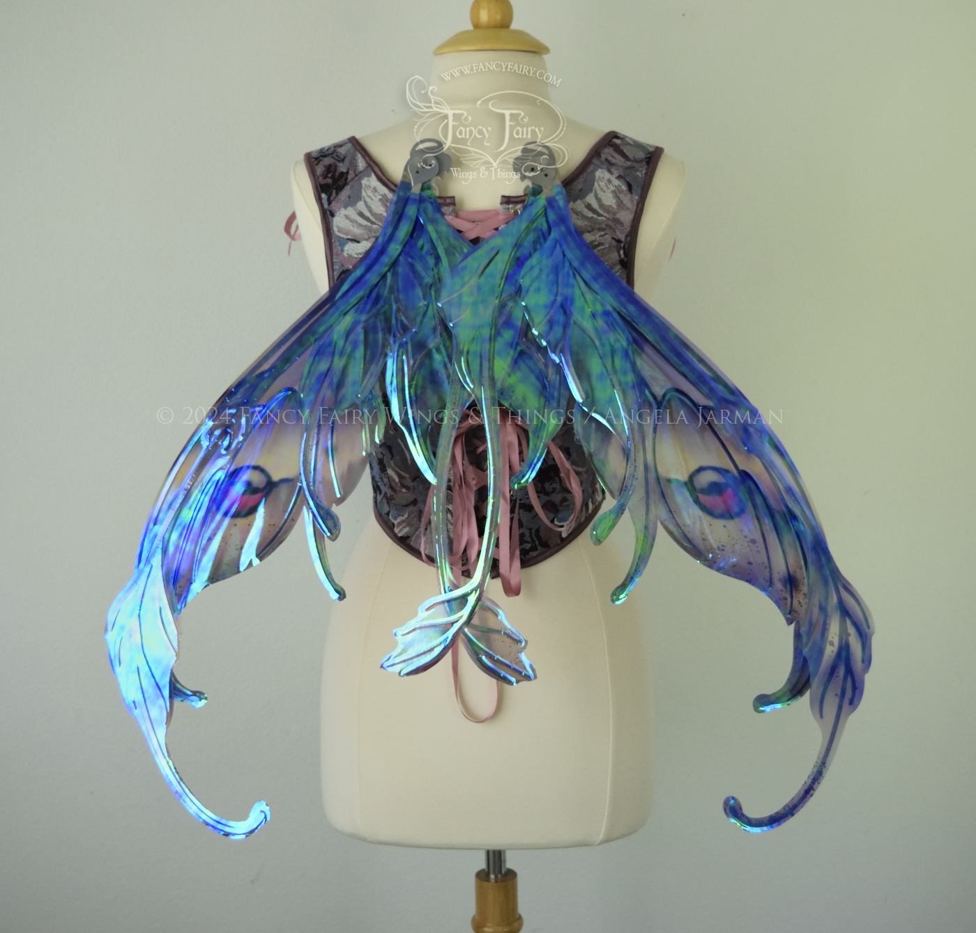 Iridescent fairy wings with antennae in purples, blues, and black with red accent and silver veins, back view in resting position