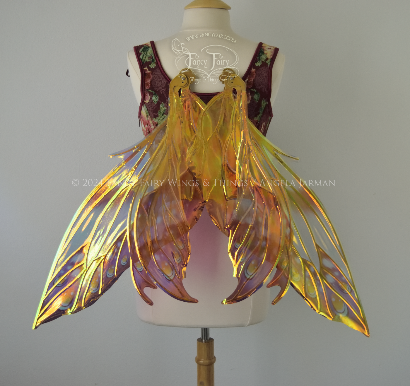 Large elongated iridescent fairy wings with burgundy, orange and blue accents & gold veins, 3 panels each side, worn on a dress form, back view, in resting position