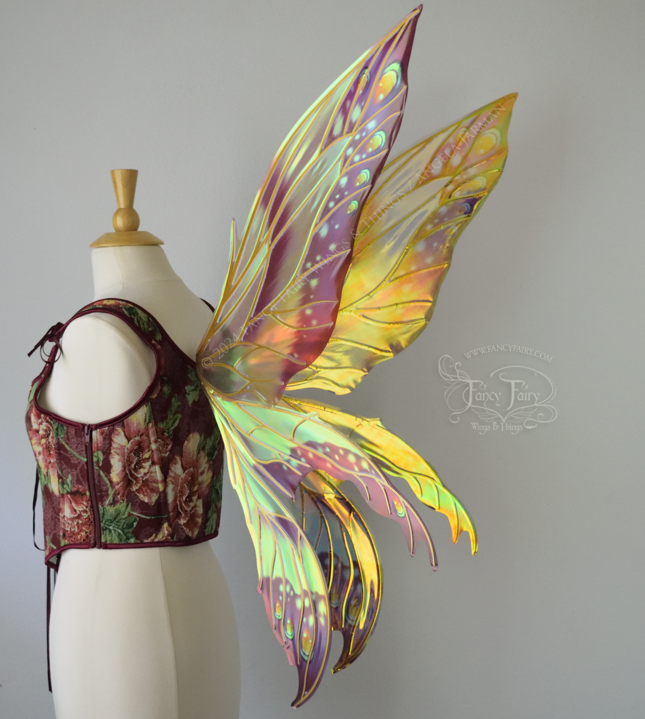 Large elongated iridescent fairy wings with burgundy, orange and blue accents & gold veins, 3 panels each side, worn on a dress form, back 3/4 view